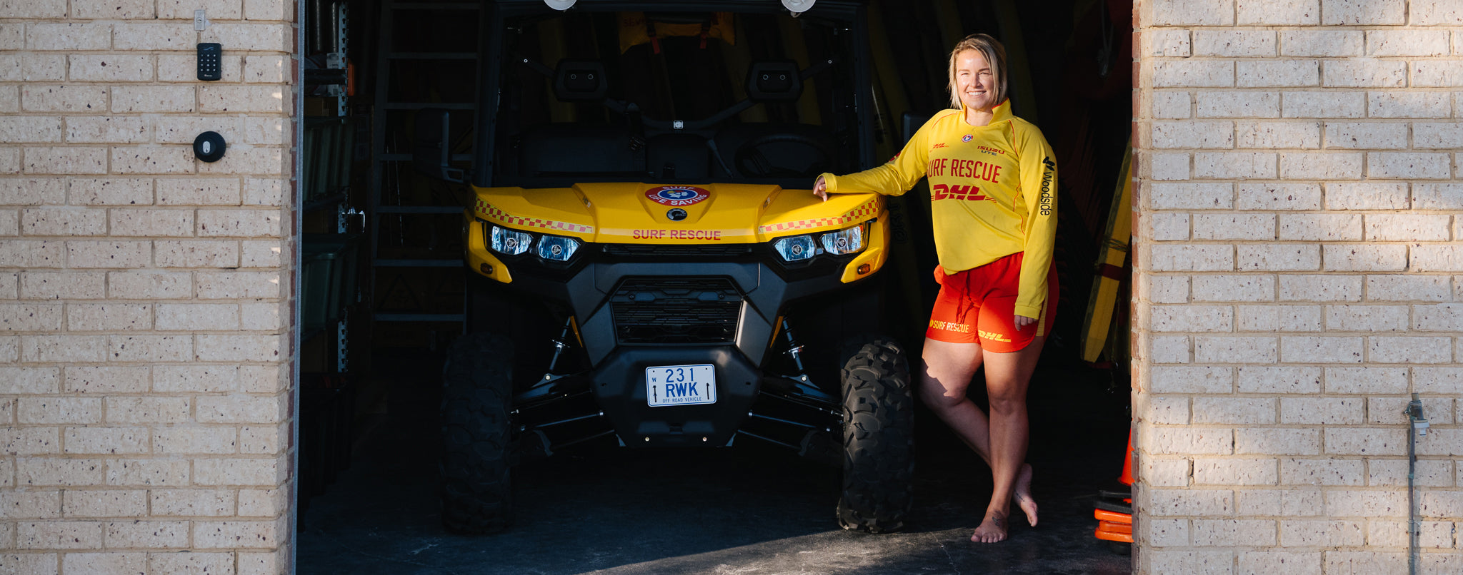 Surf lifesaver wearing supportive D+ cup swimsuit for ocean patrol and surf boat training