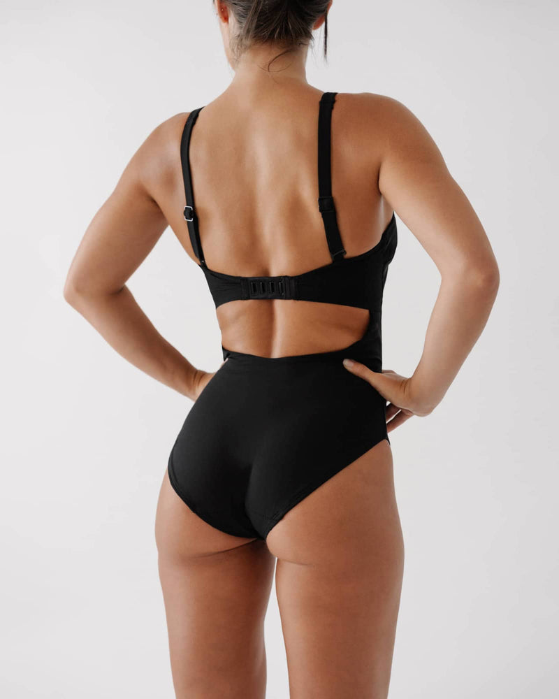 Person wearing the Bouncedown onepiece black swimsuit on a white background